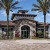 a building with palm trees and a brick driveway