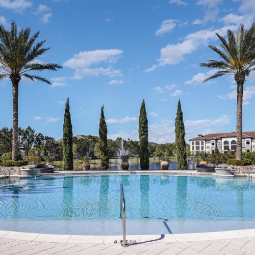Relax and unwind poolside a pool with trees around it