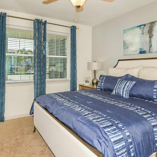 Relax and recharge in beautiful and spacious bedrooms a bedroom with a bed and a fan